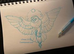 a drawing of an owl is shown on a notepad next to a blue pen