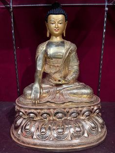 a golden buddha statue sitting on top of a table