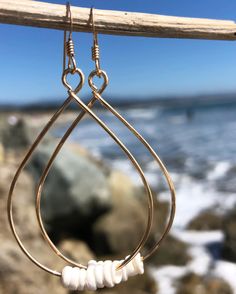 These teardrop hoops are made with 14kt gold filled or sterling silver wire. Hand-shaped and hammered. Tiny natural Puka Shell Beads are threaded along the bottom of each hoop.CHOOSE FROM 14kt GOLD OR STERLING SILVERDimensions: Approx. 2.625" long x 1.5" wide Teardrop Hoop Earrings, Puka Shell, Shell Beads, 14kt Gold, Silver Wire, Alex And Ani Charm Bracelet, Sterling Silver Earrings, Gold Filled, Shells