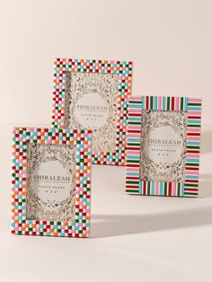 three colorful boxes with different designs on the front and back, each containing a label