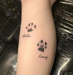 a person with a tattoo on their arm that says hello kitty and furry dog paw prints