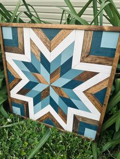 a blue and white star quilt sitting in the grass