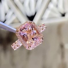 a fancy pink diamond ring hanging from a string