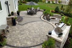 an outdoor patio with seating area and fire pit in the middle, surrounded by landscaping