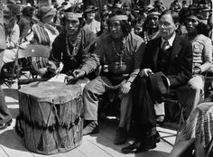 an old black and white photo of native americans playing drums on the deck of a ship