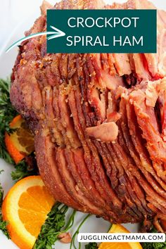 a large piece of meat on a plate with oranges and herbs next to it