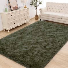 a living room with white furniture and green rug