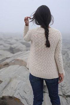 a woman standing on top of a rock covered hillside