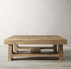 a wooden coffee table sitting on top of a hard wood floor next to a wall