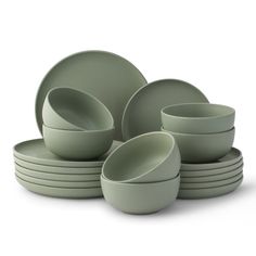 a stack of green dishes sitting next to each other on top of a white surface