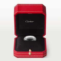 an open red box with a ring in it's center and the word cartier written on the inside