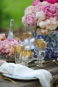 the table is set with flowers and glasses