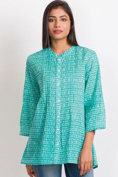 Our Amisha Cotton Tunic is a popular new addition to our sustainable apparel collection. Made with printed 100% cotton fabric, this fair trade tunic features a button down front and roll up button sleeves. These soft cotton tunic tops are free size, and are designed for an elegant, comfortable fit up to size XXL. One size fits most. Casual Cotton Kurta With Placket, Spring Green Cotton Tunic, Casual Cotton Kurta With Button Closure, Casual Turquoise Cotton Blouse, Spring Cotton Button-up Tunic, Green Top With 3/4 Sleeves And Button Closure, Casual Green Kurta For Spring, Green Cotton Henley Neckline Top, Casual Long Sleeve Blouse With Printed Motifs