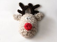 a crocheted reindeer head with red nose and antlers on it's forehead