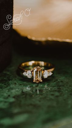 an engagement ring sitting on top of a green table