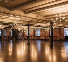 an empty room with lights hanging from the ceiling and exposed pipes in the floor,