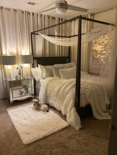 a bedroom with a four poster bed and white rugs on the floor next to it