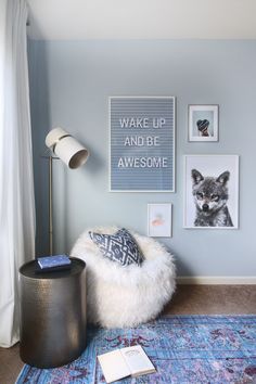 a living room with blue walls and pictures hanging on the wall, including a chair