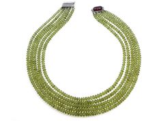 An 18K white gold multi-strand peridot bead necklace set with an elongated cabochon ruby and pavé diamond clasp. Metal: 18K White Gold Gemstone: Peridot: 985 carats Gemstone: Ruby: 10.58 carats Gemstone: Diamonds: 0.26 carats Design Era: Contemporary Green Faceted Necklace Fine Jewelry, Green Faceted Round Beads Necklace, Luxury Green Faceted Necklace, Peridot Beaded Necklace, Luxury Faceted Peridot Jewelry, Ruby Necklace, Knot Necklace, Multi Strand, Pave Diamonds