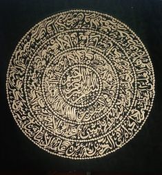 an intricately designed plate with arabic writing on black velvete, in the shape of a circle