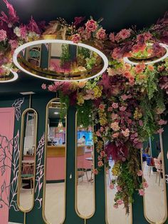 a room filled with mirrors and flowers hanging from the ceiling