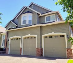 a two story house with three garages in the front