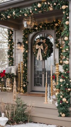 christmas decorations on the front door of a house with wreaths and lights around it