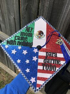 someone is holding up a graduation cap decorated with the colors of the american and mexican flag