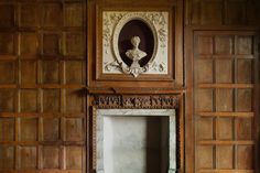 an old fireplace in the corner of a room with wooden paneling and carvings on the wall