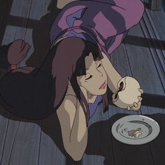 a woman laying on the floor next to a plate