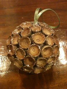 an ornament made out of wine corks on a wooden table with a green ribbon