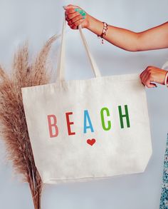 "Colorful Beach Tote Bag Two Sizes Medium Measurements 16\" W x 15\" H x 3\" D Large Measurements 20\" W x 15\" H x 5\" D 22\" Handles 100% Cotton Made in the USA" Canvas Vacation Gift Bag For Beach Season, Canvas Gift Bag For Beach Vacation, Canvas Gift Bag For Vacation Beach Season, White Canvas Bag For Beach Vacation, White Canvas Bag For Vacation During Beach Season, Beachy Rectangular Bag For Weekend, Beachy Bags For Weekend Vacation, Beachy Bags For Weekend Beach Season, Beachy Weekend Bag Rectangular