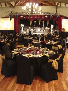 a banquet hall set up with black and gold linens