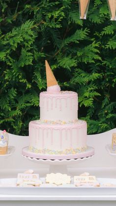 a pink and white cake sitting on top of a table