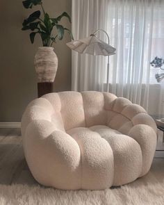 a large white chair sitting in front of a window