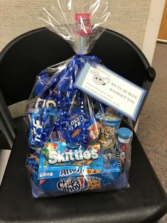 a chair that has some kind of gift bag on top of it, sitting in front of a cubicle