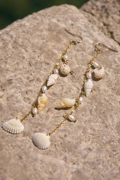 Multi charm earring with shells. 4" Long Affordable Beaded Shell Jewelry, Beach Jewelry With Dangling Metal Charms, Shell Charms Jewelry, Beach Jewelry With Dangling Charms, Shell Dangle Jewelry Gift, Shell Dangle Jewelry For Gifts, Beach Dangle Charms Jewelry, White Shell Dangle Jewelry, Beach Dangle Jewelry