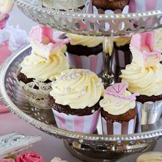 cupcakes are arranged on three tiered plates