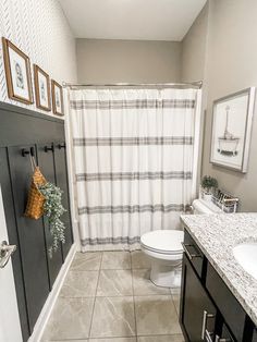 a bathroom with a toilet, sink, and shower curtain is shown in this image