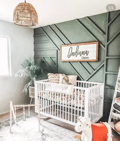 a baby's room with a green wall and white crib in the corner