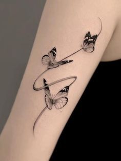 a woman's arm with two butterflies on it and the word love written in cursive writing