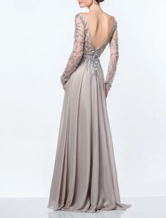 a woman in a long grey dress with an open back and beading on it