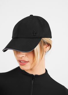 a woman wearing a black hat with the letter d on it and a zippered back