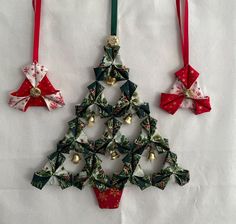 an ornament shaped like a christmas tree is hanging on a white tablecloth