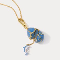 Dive into ocean wave with our Dolphin Egg Locket Necklace! 🐬 This enchanting piece features a playful dolphin embracing a delicate egg locket, creating a cute and endearing design. Perfect for ocean lovers, this necklace adds a touch of charm and marine magic to your style. Express your love for these intelligent creatures and make a splash with this delightful accessory! DETAILS Plating: 18K Gold Materials: 18K Gold on Brass, Enamel Measurements: Length:  24.80 "(63cm)  + Extender: 2.36"(6cm) Egg Necklace, Dolphin Gifts, Ocean Necklace, Pearl Gifts, Fish Necklace, Enamel Necklaces, Disney Jewelry, Ocean Wave, Brass Necklace