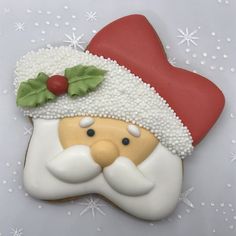 a decorated cookie with a santa clause on it's face and holly berry decoration