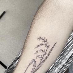 a tattoo on the arm of a man that has a plant growing out of it