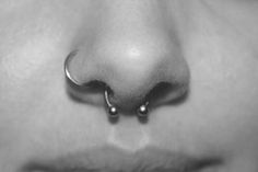 a close up of a person's nose with the words get a sepum piercing