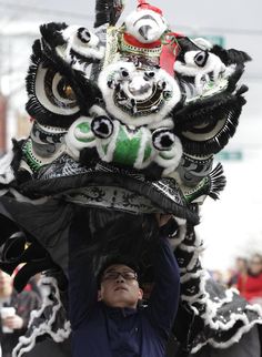 a man holding up a dragon head in the air