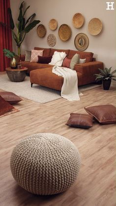 a living room filled with lots of furniture and pillows on top of wooden flooring